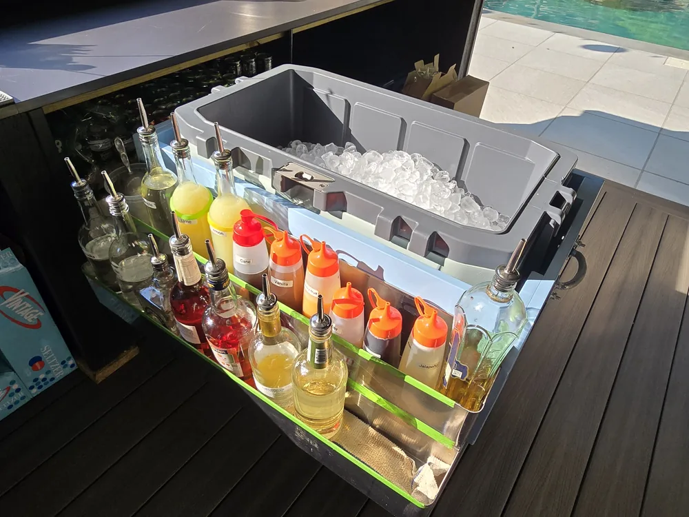 Professional speed rail and ice well set up for craft cocktail service at a private home